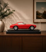 Cased Ferrari 1:8 scale model displayed on a matte black Amalgam Collection Memorial Riser
