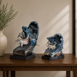 Serenade bronze dolphin sculptures, full-size and keepsake, on a wooden table