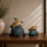 Freedom bronze sea turtle sculptures, full-size and keepsake, on a wooden table
