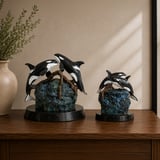 Devotion bronze orca sculptures, full-size and keepsake, on a wooden table