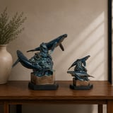 Majestic bronze humpback whale sculptures, full-size and keepsake, on a wooden table