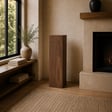 Walnut Tribute Pillar art display pedestal standing beside a fireplace in a warm living room
