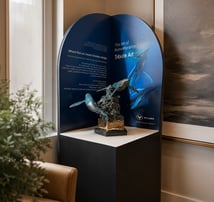 Wyland Gallery Pedestal displaying a Wyland bronze sculpture with a curved arched backdrop in a contemporary interior